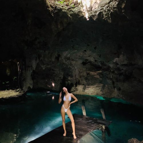 Girl posing on the deck leading to a cenote, underground