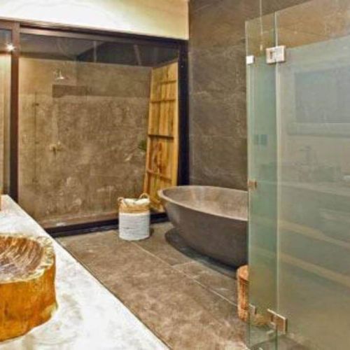 Raw cement style full bathroom with wood detailing